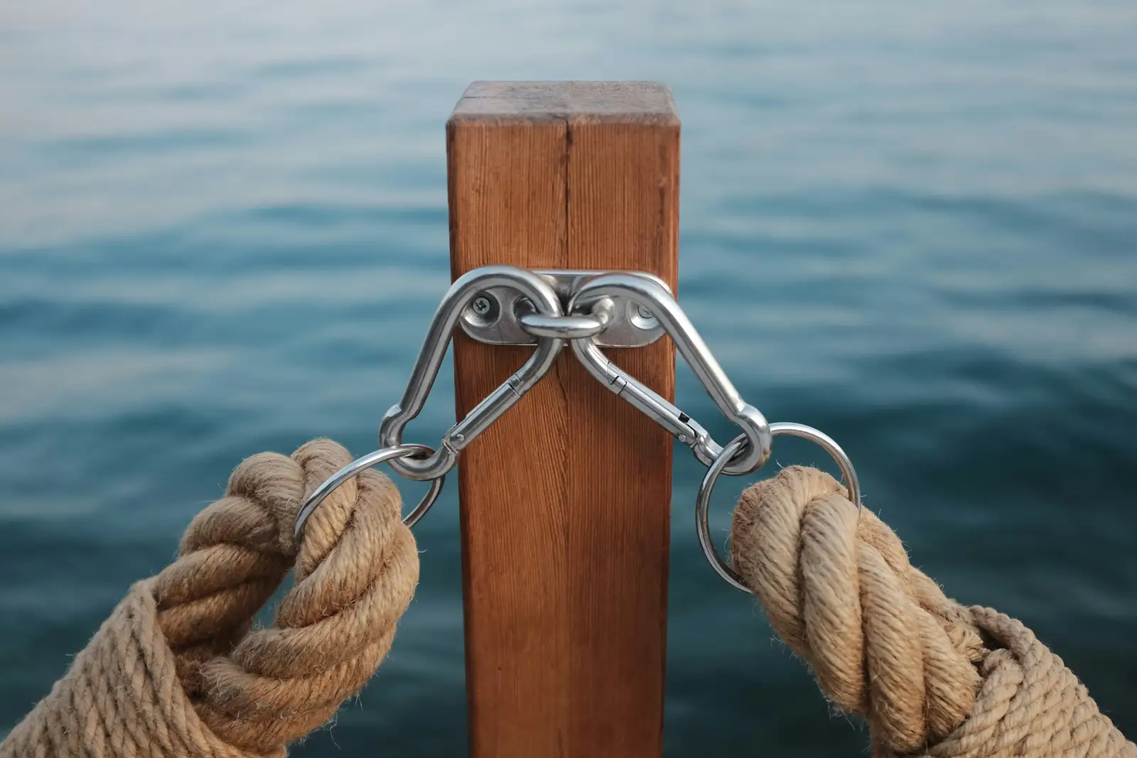 Thick line tied to a deck cleat, calm water behind